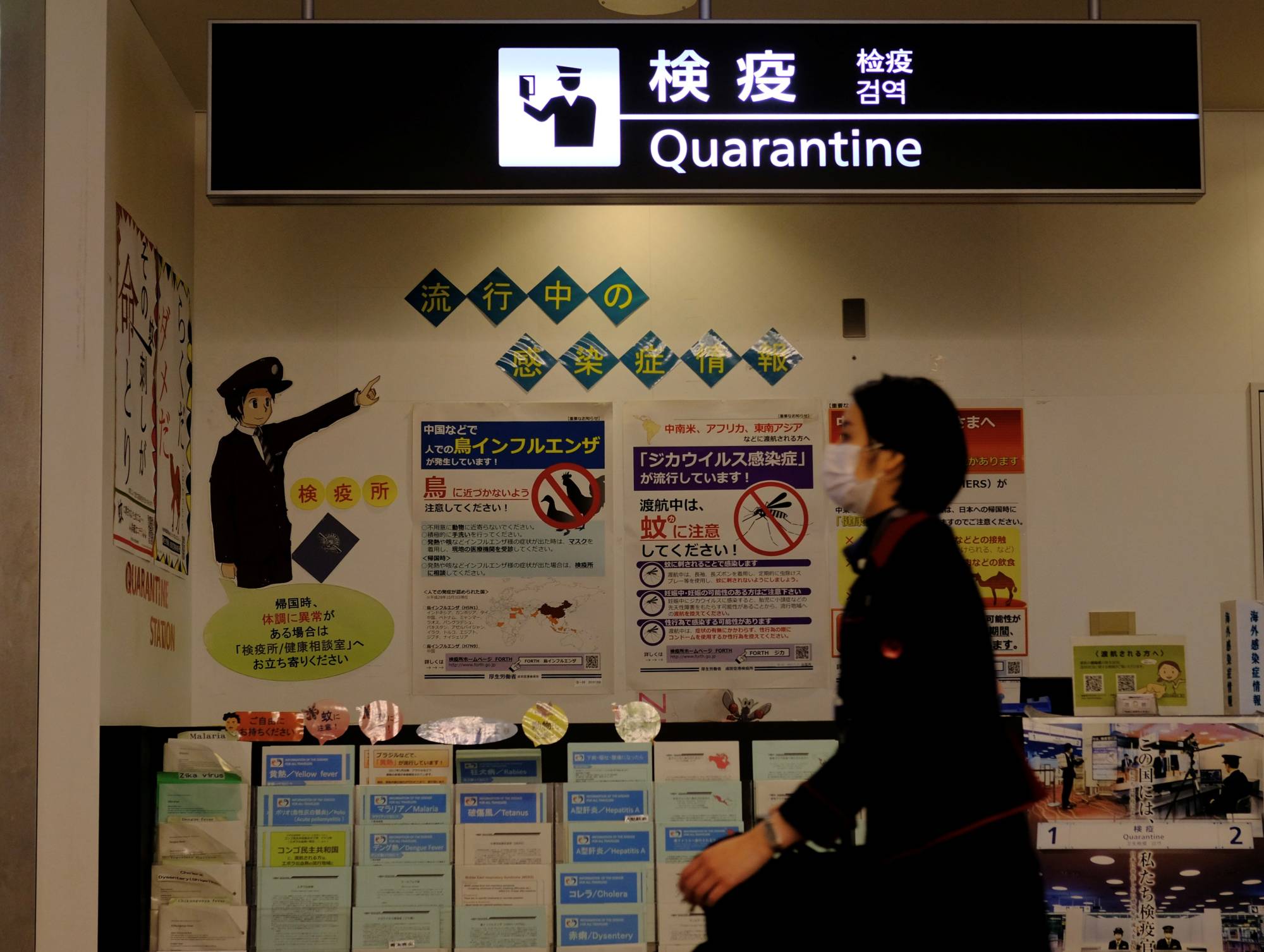 The goal: An airline employee walks past the quarantine counter at Narita airport. However, it's difficult for non-Japanese entering the country to even make it this far as they first have to clear many hurdles in their home countries. | REUTERS